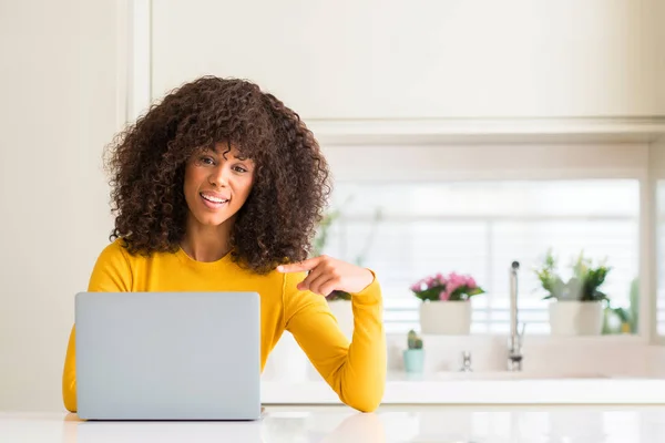 非洲裔美国妇女使用计算机笔记本电脑在厨房非常高兴地指着手和手指 — 图库照片