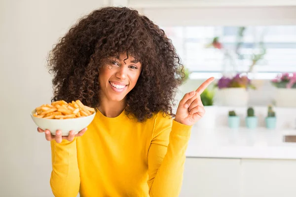 自宅側の手と指で指す非常に満足チップをポテトのプレートを保持しているアフリカ系アメリカ人の女性 — ストック写真