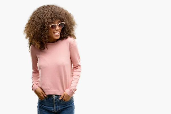アフリカ系アメリカ人の女性が自然な表現の顔に笑みを浮かべて側に離れているピンクのサングラスをかけています 自信を持って笑ってください — ストック写真