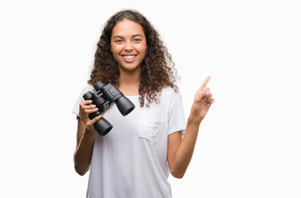 Junge Hispanische Frau Blickt Glücklich Durch Ein Fernglas Und Zeigt — Stockfoto