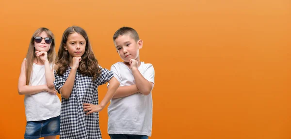 Grupo Niños Niñas Niños Sobre Fondo Naranja Cara Seria Pensando —  Fotos de Stock