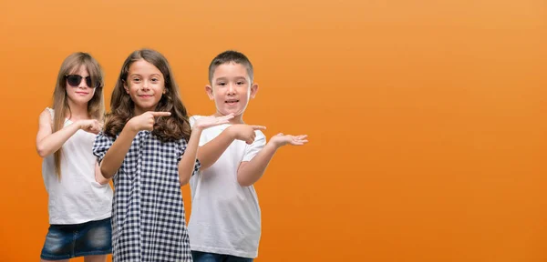 Group Boy Girls Kids Orange Background Very Happy Pointing Hand — Stock Photo, Image