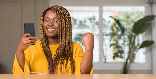 Αφρικανική Αμερικανική Γυναίκα Χρησιμοποιώντας Smartphone Ακουστικά Ουρλιάζοντας Περήφανος Και Γιορτάζει — Φωτογραφία Αρχείου