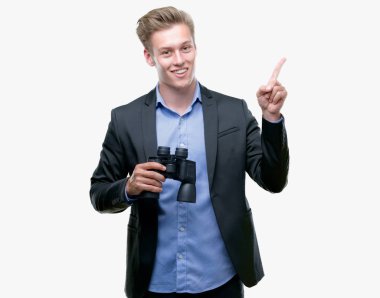 Genç yakışıklı sarışın adam dürbün el ve parmak ile tarafına işaret çok mutlu üzerinden seyir