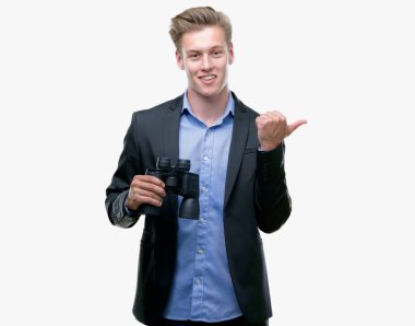 Genç yakışıklı sarışın adam el ve parmak ile yukarı dönük mutlu yüz gülümseyen ile dürbün üzerinden seyir