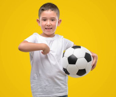 Koyu saçlı küçük çocuk futbol topu sürpriz yüz işaret parmağı kendisine ile oynama