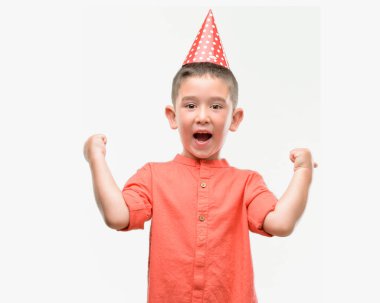 Duygu tezahürat gurur çığlık ve zafer ve başarı çok heyecanlı, kutluyor Doğum günü şapkası koyu saçlı küçük çocuk