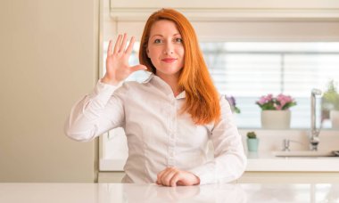 Kızıl saçlı kadına gösterilen ve parmakları ile işaret mutfak beş kendinden emin ve mutlu gülümseyerek iken numara.