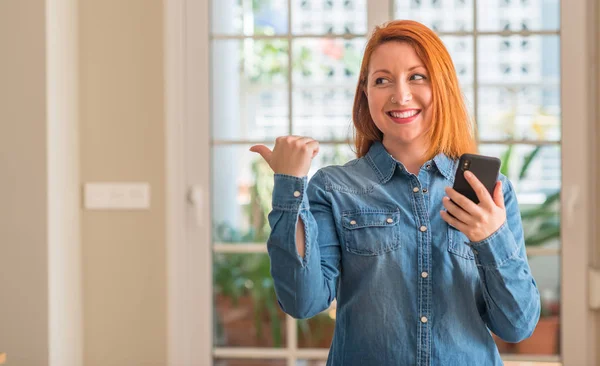 Κοκκινομάλλης Γυναίκα Στο Σπίτι Χρησιμοποιώντας Smartphone Δείχνοντας Χέρι Και Δάχτυλο — Φωτογραφία Αρχείου