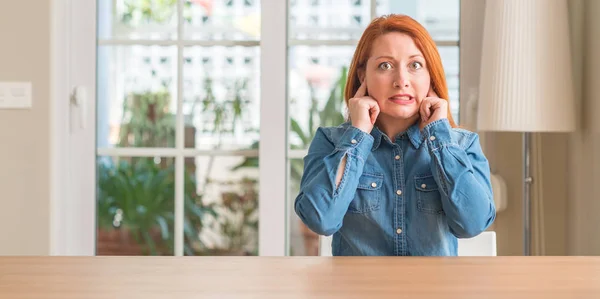 Mulher Ruiva Casa Cobrindo Orelhas Com Dedos Com Expressão Irritada — Fotografia de Stock