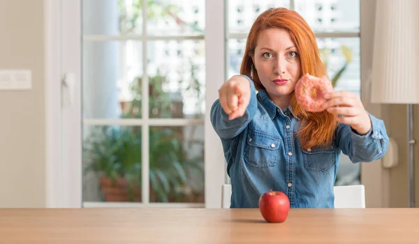 Рыжая Женщина Выбирает Между Яблоком Пончиком Указывая Пальцем Камеру Знак — стоковое фото