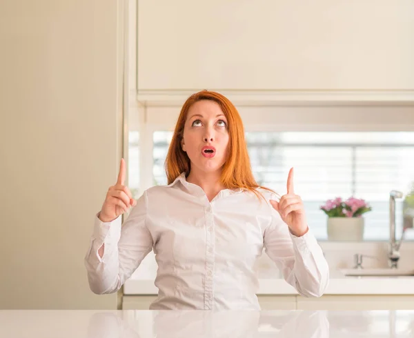 Redhead Woman Kitchen Amazed Surprised Looking Pointing Fingers Raised Arms — Stock Photo, Image