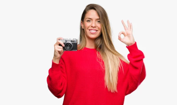 美丽的年轻女子手持老式相机做 标志与手指 优秀的符号 — 图库照片