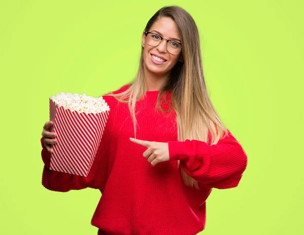 Mulher Bonita Comendo Pipocas Muito Feliz Apontando Com Mão Dedo — Fotografia de Stock