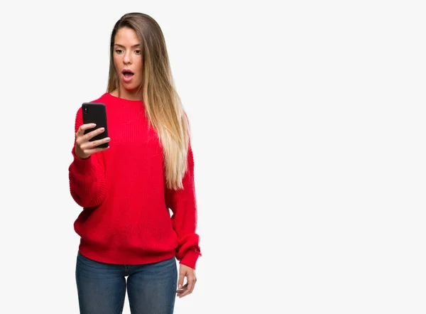 Piękna Młoda Kobieta Przy Użyciu Smartfona Przestraszony Szoku Ścianą Niespodzianka — Zdjęcie stockowe