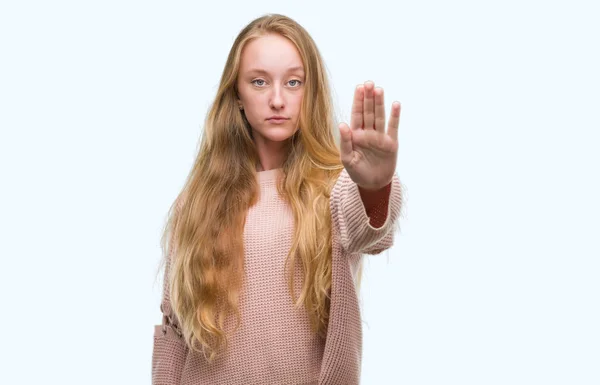 穿着粉红色毛衣的金发女郎停止用手掌唱歌 脸上带有否定和严肃手势的警告表达式 — 图库照片
