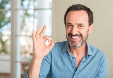 Parmak, mükemmel sembolü ile ok işareti yapan yakışıklı orta yaş erkek