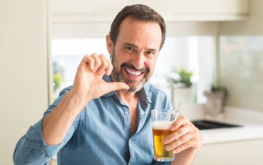 El ve parmak ile yukarı dönük mutlu yüz gülümseyen ile bira içme orta yaş erkek