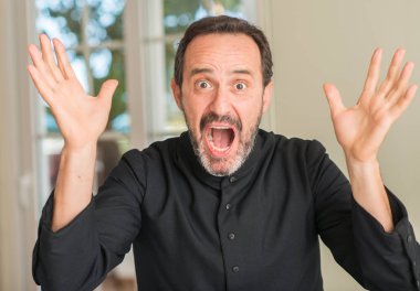 Hıristiyan rahip adam çok mutlu ve heyecanlı, kazanan ifade büyük gülümseme ile çığlık ve ellerini kaldırdı zaferini kutluyor