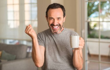 Duygu tezahürat gurur çığlık ve zafer ve başarı çok heyecanlı, kutlama bir fincan kahve içme orta yaş erkek