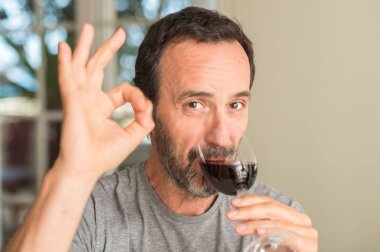 Parmak, mükemmel sembolü ile ok işareti yapıyor şarap içme orta yaş erkek