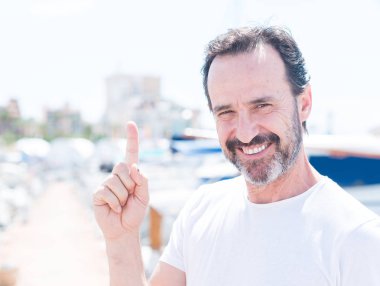 Yakışıklı ortadaki adam Marina bir fikirle sürpriz yaş ya da gülen yüz, bir numara ile işaret parmağı soru