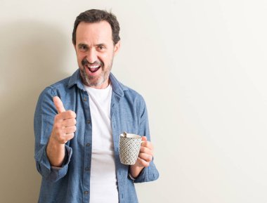 Komuta sizde ok işareti, başparmak ile parmak, mükemmel işareti yapıyor kocaman bir gülümseme ile mutlu bir kupa kahve içme