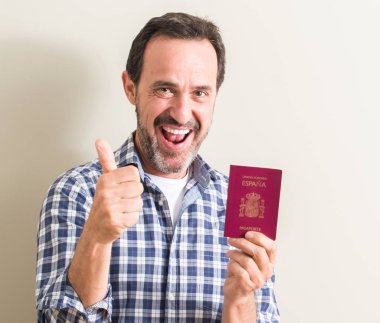 Komuta sizde ok işareti, başparmak ile parmak, mükemmel işareti yapıyor kocaman bir gülümseme ile İspanyol pasaportu mutlu holding