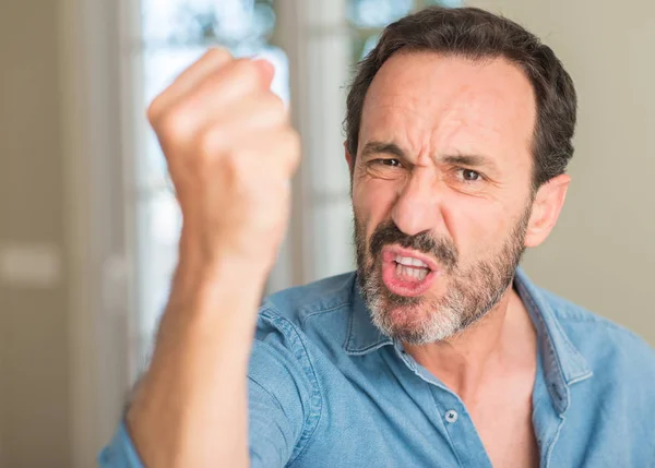 Handsome middle age man annoyed and frustrated shouting with anger, crazy and yelling with raised hand, anger concept