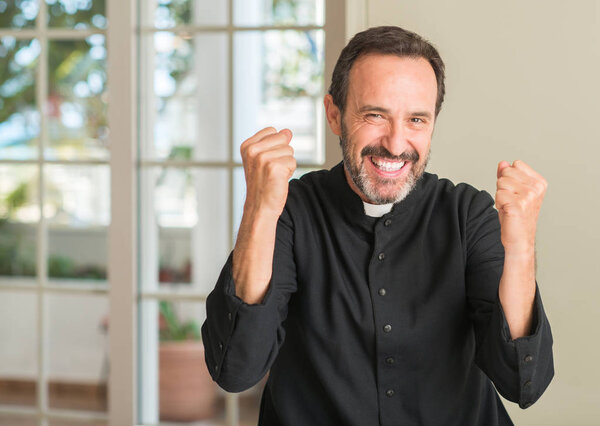 Christian priest man screaming proud and celebrating victory and success very excited, cheering emotion