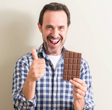 Komuta sizde yeme çikolata bar ok işareti, başparmak ile parmak, mükemmel işareti yapıyor kocaman bir gülümseme ile mutlu