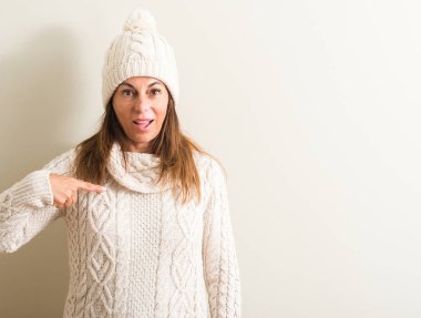 Yün kış şapkası kendisi için sürpriz yüz işaret parmağı ile orta yaş kadın