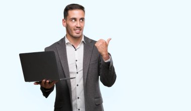 El ve parmak ile yukarı dönük mutlu yüz gülümseyen ile bilgisayar dizüstü kullanarak yakışıklı genç