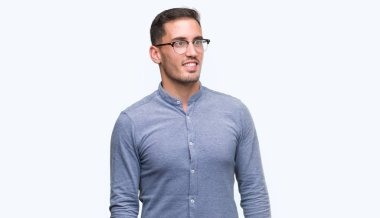 Yakışıklı genç zarif gözlük uzak tarafına yüzünde, doğal ifade gülümseme ile seyir adam. Kendine güvenen gülüyor.