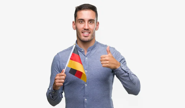Przystojny Młody Mężczyzna Trzymając Banderą Niemiec Szczęśliwy Wielkim Uśmiechem Robi — Zdjęcie stockowe