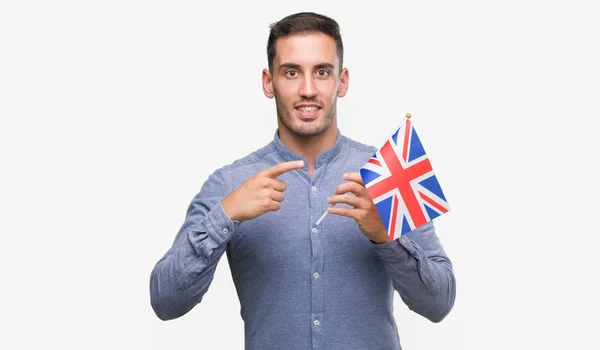 Joven Guapo Sosteniendo Una Bandera Del Reino Unido Muy Feliz —  Fotos de Stock