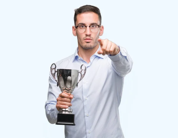 Joven Guapo Sosteniendo Trofeo Señalando Con Dedo Cámara Signo Mano — Foto de Stock