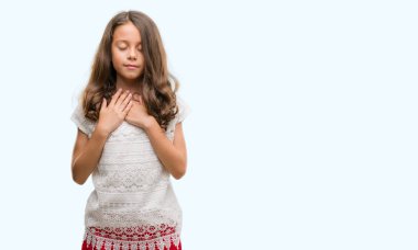 Esmer Latin kız göğüs kapalı gözlerle ellerinde ve yüzünde minnettar jest ile gülümseyen. Sağlık kavramı.