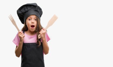 Aşçı üniforması bir sürpriz yüz, korkuyor ve heyecanlı korku ifadesi ile şok korkmuş esmer Latin kız