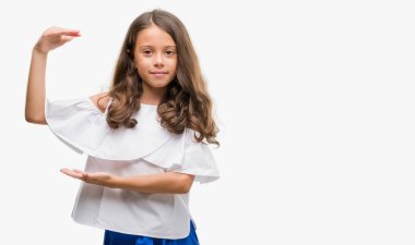 İle büyük ve büyük boy işaret, ölçü birimi sembol gösteren el eller esmer Latin kız. Kameraya bakarak gülümsüyordu. Ölçüm kavramı.