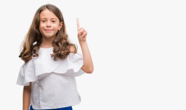 Gösterilen ve kendinden emin ve mutlu gülümseyen bir parmak ile işaret eden oktan yukarı esmer Latin kız.