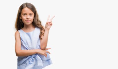 Esmer Latin kız mutlu yüz zafer işareti yaparken kameraya göz kırpıyor ile gülümseyen. İki numaralı.