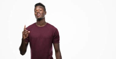 Genç Afro-Amerikan adam bir fikir ya da soru işaret parmağı gülen yüz, bir numara ile sürpriz