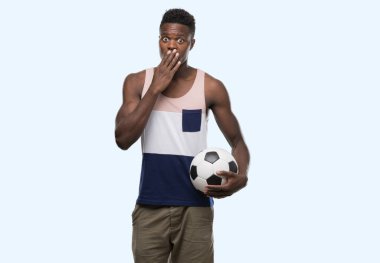 Futbol futbol topu kapak ağız hata, korku, ifade için utanç ile şok eliyle tutan genç Afro-Amerikan adam sessizce, gizli kavramı korkuttu