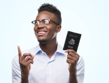Bir fikir ya da soru işaret parmağı gülen yüz, bir numara ile Amerika Birleşik Devletleri pasaport tutan genç Afrikalı Amerikalı adam şaşırttı