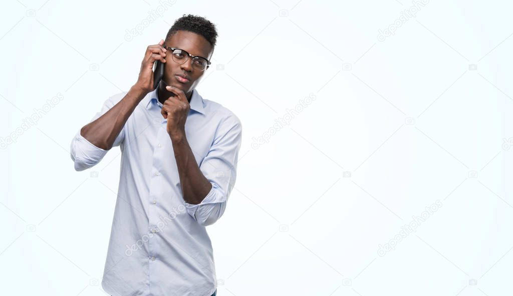 Young african american man using smartphone serious face thinking about question, very confused idea