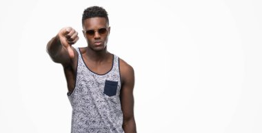 Genç Afro-Amerikan adam kızgın yüzü, eksi işareti aşağı antipati başparmak ile gösterilen, ret kavramı ile güneş gözlüğü takıyor