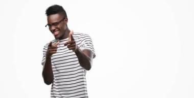 Gözlük ve Donanma t-shirt işaret parmakları için fotoğraf makinesi ile mutlu ve komik yüz giyen genç Afro-Amerikan adam. İyi enerji ve vibes.