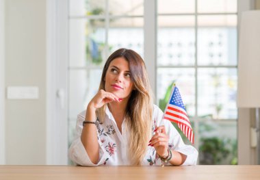 Genç kadın, Amerika Birleşik Devletleri ciddi bir yüz düşünme hakkında soru, çok karışık fikir ev holding bayrağı