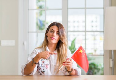 Genç kadın evde Çin bayrağı çok mutlu el ve parmak ile işaret tutan